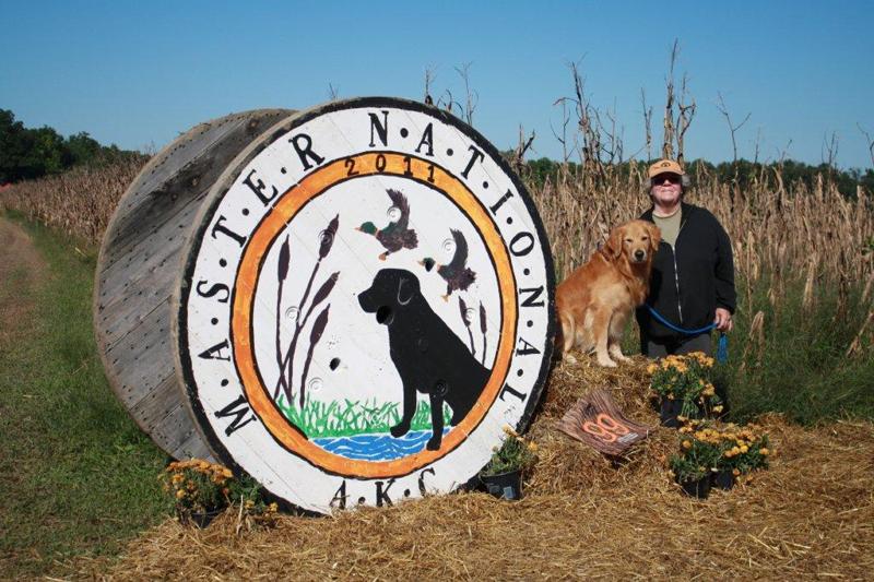 Claire and Eddy next to Master National AKC Logo Sign